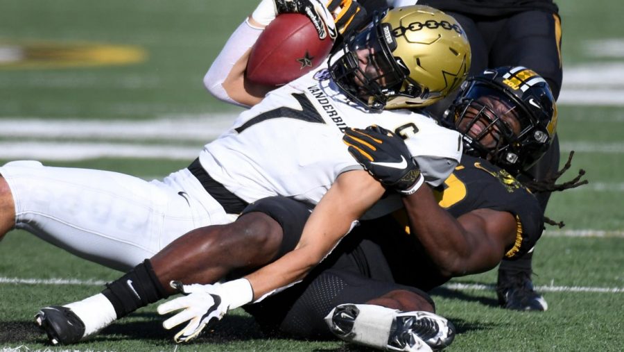 Cam Johnson (7) is pulled down by Missouri linebacker Nick Bolton on Nov. 28, 2020. (AP Photo/L.G. Patterson)